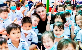 Ca sĩ Dương Tùng Nhân được hàng trăm học sinh vây quanh khi về trường xưa từ thiện
