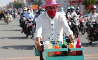 Color Man Bửu Điền đầu đội nón cói, chân đi dép, đạp xe bán đá bào trong Tiếng Rao 4.0